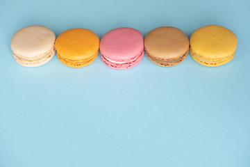 Top view of colorful macaron or macaroon on blue background with copy space