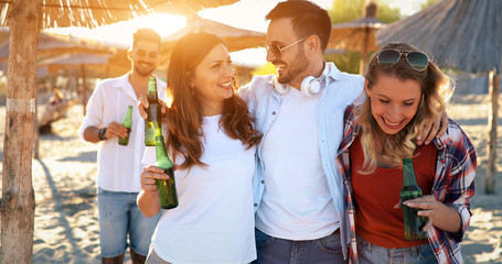 Group of young friends laughing and drinking beer