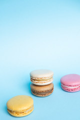 Top view of tasty colorful macaroons on blue background. Copy space