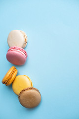 Top view of tasty colorful macaroons on color background with copy space
