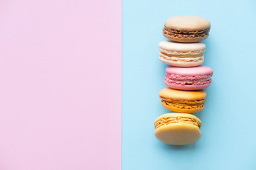 Cake macaron or macaroon on color background from above with copy space