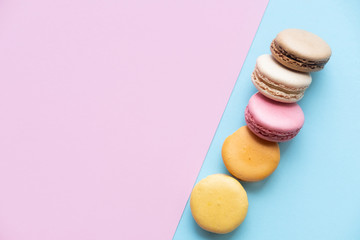 Sweet colorful French macaroon biscuits on colorful background. Copy space
