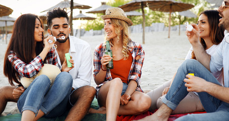 Group of young friends laughing and drinking beer