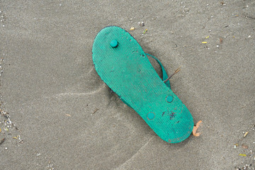 Spilled garbage on the beach of a big city. Empty used dirty plastic bottles, children's plastic...