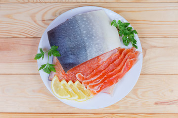 Partly sliced salted arctic char on dish on rustic table