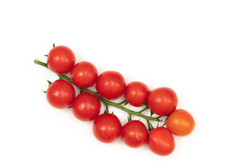 A branch of red cherry tomatoes on a white background. Small and juicy vegetable is rich in vitamins and trace elements. Healthy food. Fresh and organic vegetables. Raw food