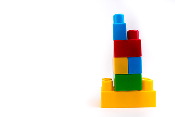 Lot of colorful rainbow toy bricks background. Bricks tower. Educational toy for children Isolated on white background with copy space.