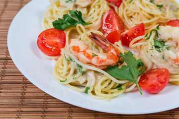 Cooked Spaghetti pasta with shrimp tails and cherry tomatoes closeup