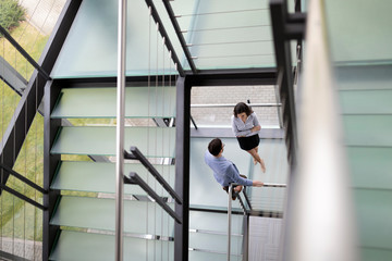 Young business people climb the stairs in the office
