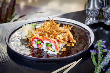 Front view on warm roll with tuna, salmon and scrambled eggs. Suchi. japanese food style. Seafood. Healthy, balanced, dieting meal. sushi rolls set on dark plate. Copy space, food background.