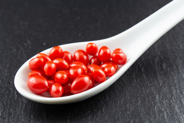 fresh goji berries in a white porcelain spoon