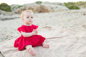 Beautiful little baby girl sitting on the beach