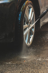 washing the wheels of the car with a hose