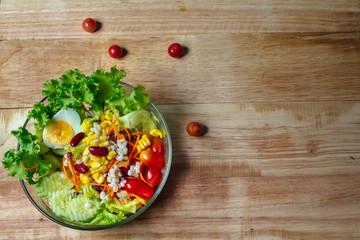 Top view salad bowl on wooden 