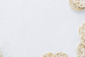 An overhead view of puffed rice cakes with grains on white paper