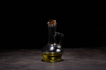 Extra virgin healthy Olive oil with fresh olives on dark wooden background
