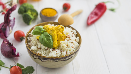 Healthy fried rice with chicken; onion; cherry tomato and red chili pepper over white desk