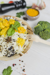 Healthy chicken fried rice; basil leaves in plate with wooden fork and vegetables