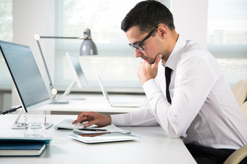 Serious businessman working with computer