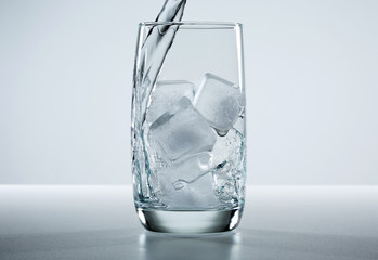 Beautiful splash of water in a glass with ice