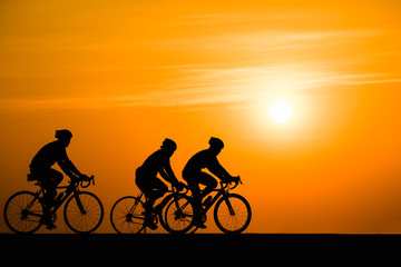 Obraz na płótnie Canvas Silhouette man cycling on sunset background