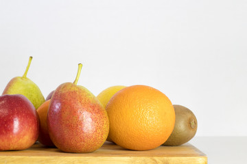 red Apple, pear, lemon, orange, kiwi, peach on white background, copy space