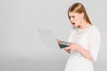 shocked girl using laptop on grey with copy space