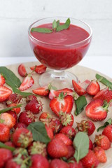 Sliced ​​strawberries on a board and strawberry fresh in a bowl