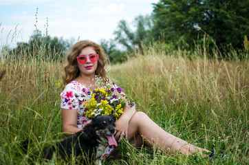 Happy girl on the field collects flowers