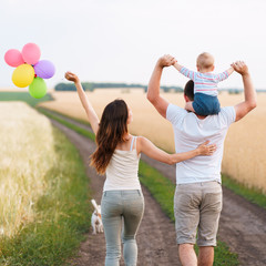 Fototapeta premium Parents and son family portrait. Daddy, mom and child having fun outdoors