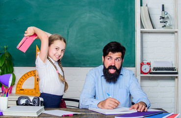 literature lesson. private lesson. small girl child with bearded teacher man in classroom....