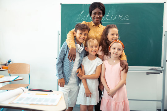 Loving Happy Teacher Hugging Her Smart Diligent Pupils