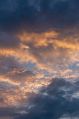 Fototapeta premium beautifully illuminated sun golden clouds in the dark evening sky