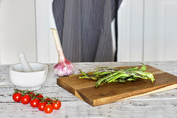 Green beans on wooden cutting board. Rustic wooden table