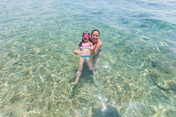 Mother and daughter having fun together in the sea during vacation