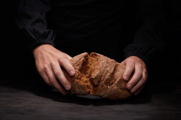 So, break bread with me. Cropped view of male Chef breaking freshly Baked Sourdough Bread, focus on...
