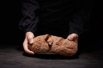 So, break bread with me. Cropped view of male Chef breaking freshly Baked Sourdough Bread, focus on...