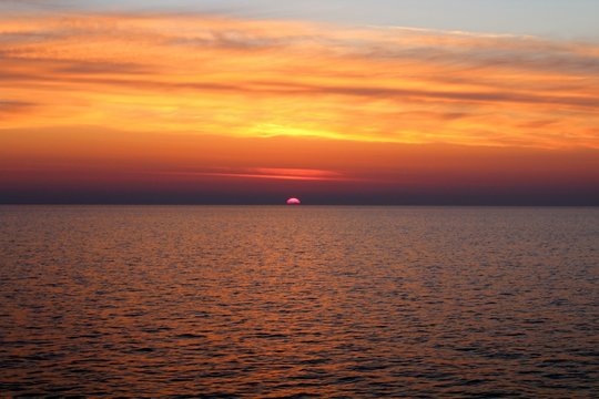 evocative image of sunrise over the sea with the sun rising over the horizon