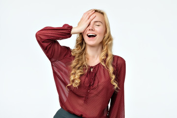 Young blonde woman surprised with hand on head for mistake, remember error. Forgot, bad memory...