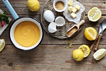 Lemon curd with ingredients on a rustic wooden table
