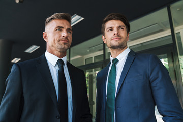 Portrait closeup of confident businessmen partners standing outside job center during working...