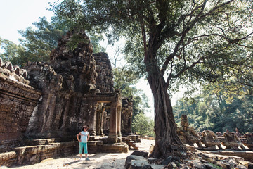 Adult woman tourist posing beside ancient Khmer ruins in Cambodia, Angkor Wat, Siem Reap