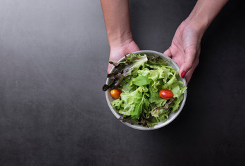 Fresh healthy vegetable salad with tomato, carrot, spinach, lettuce in plate on table background with free text space for diet menu.