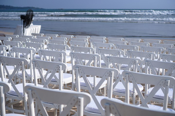 White chairs stand on the beach in rows. Outdoor conference. Religious meeting of the church for the wedding. Stock photo