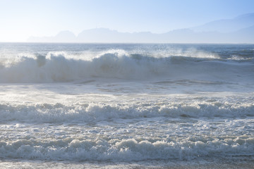 Amazing sunny day with endless horizon and incredible foamy waves. Beautiful beach, California, USA seascape and sun on blue sky background