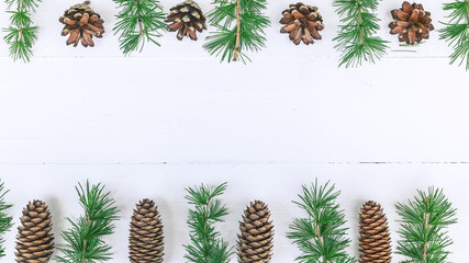 Fototapeta na wymiar Christmas border. Fir branches, cones on a white rustic background. Horizontal shot