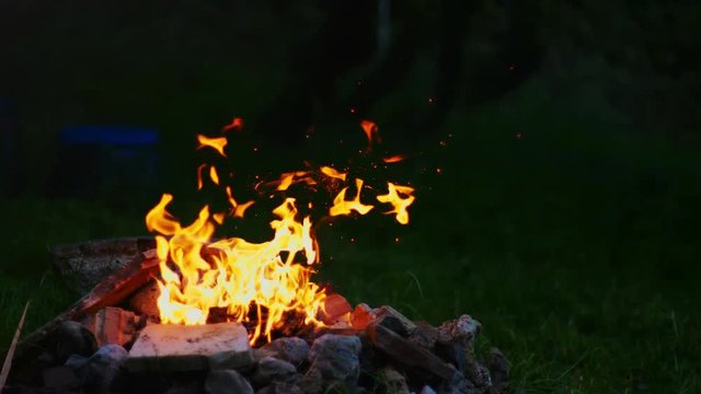 Footage of a Campire in the Evening with a dark grassy background. Shot in 4K