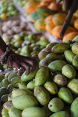 Mangoes are sold on the market in Asia. Sale of vegetarian fruits outdoors. Stock photo