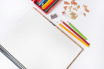 Pencils and sharpener near notebook