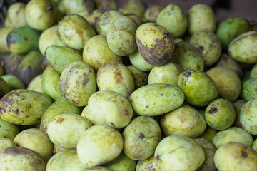 Mangoes are sold on the market in Asia. Sale of vegetarian fruits outdoors. Stock photo